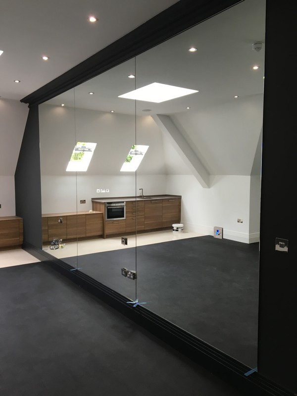 Frameless glass partition in loft conversion by Muswell Hill glaziers