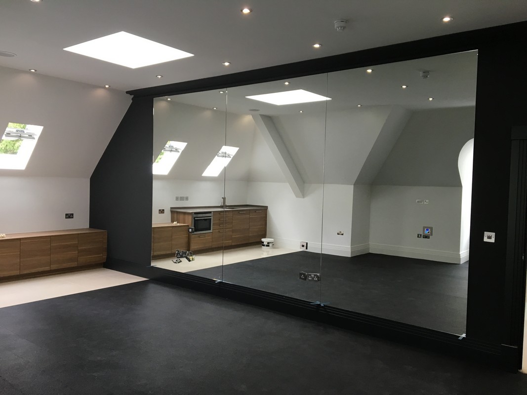 Frameless glass wall dividing loft conversion in Muswell Hill